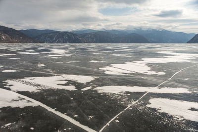 View of beautiful drawings on ice from cracks on the surface of lake teletskoye in winter, russia