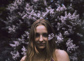 Portrait of woman against flowering plants