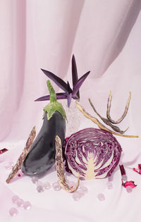 Eggplant, green beans and purple cabbage on light violet curtain. healthy food concept. still life