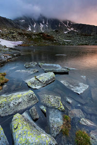 Scenic view of lake by mountains against sky