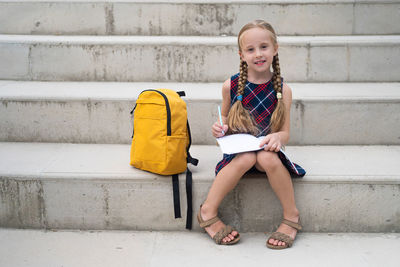 Full length of cute girl sitting on staircase