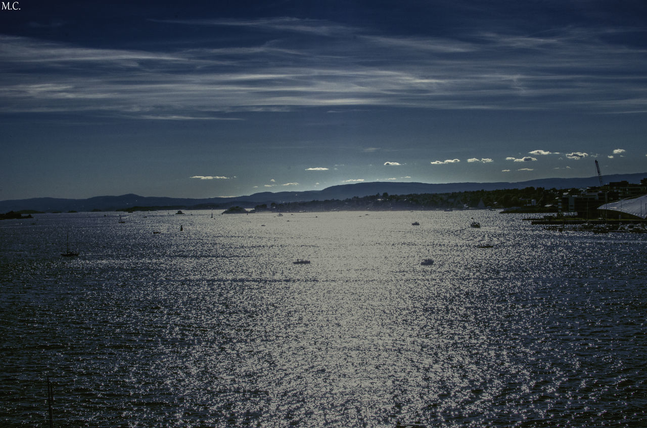 SCENIC VIEW OF SEA AGAINST MOUNTAIN