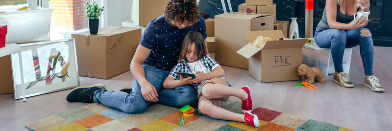 Rear view of friends sitting in box at home