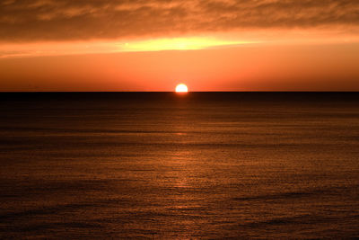 Scenic view of sea against orange sky