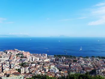 High angle view of townscape by sea against sky