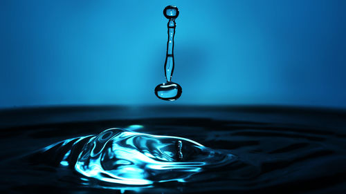 Close-up of drop falling on water