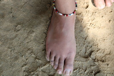 Low section of woman standing at beach