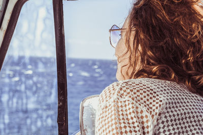 Close-up of woman looking through window while sitting in car