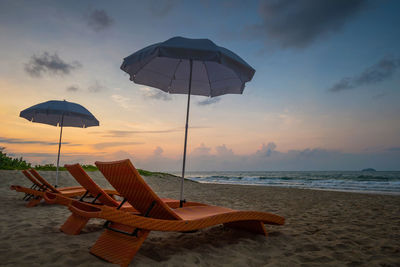 Lifeguard hut on beach against sky during sunset