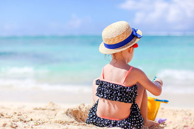 Rear view of woman wearing hat on beach