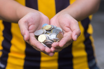 Midsection of man holding coins