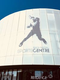 Low angle view of information sign against sky in city