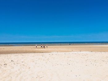 Scenic view of beach against blue sky