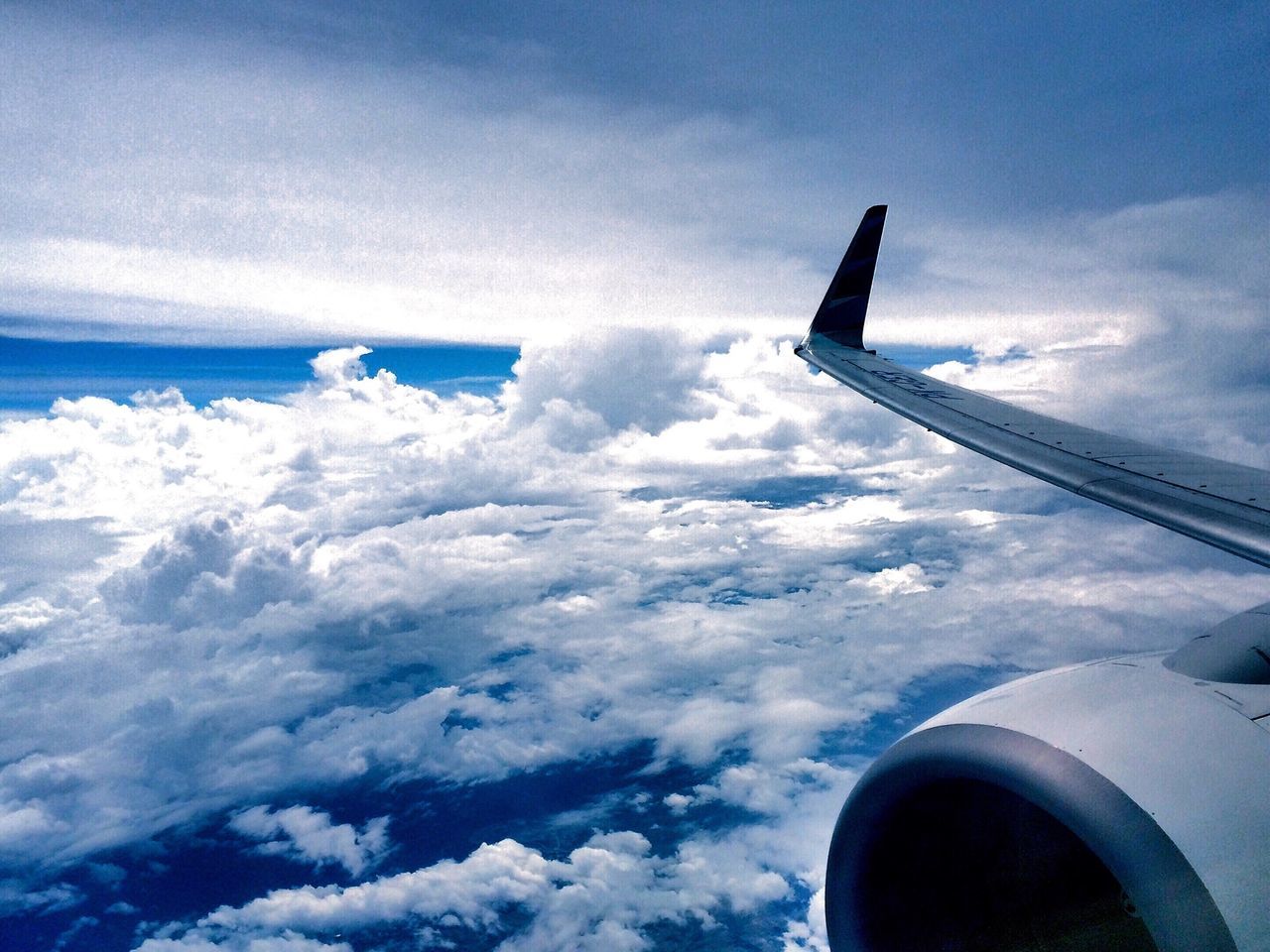 transportation, airplane, mode of transport, air vehicle, aircraft wing, part of, cropped, flying, sky, journey, travel, cloud - sky, on the move, mid-air, vehicle part, aerial view, cloud, scenics, public transportation, cloudscape