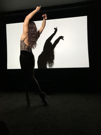 Low angle view of silhouette woman standing in nightclub