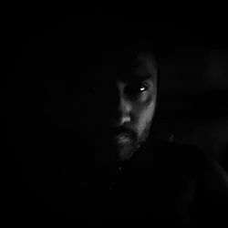 Portrait of man against black background