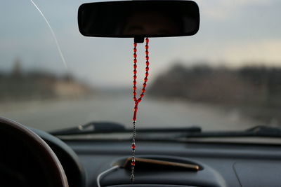 Close-up of red car windshield on road