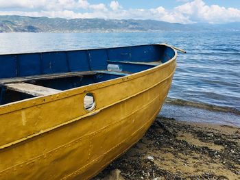 Boat moored on beach against sky