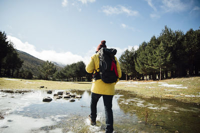 Full length rear view of person photographing against sky