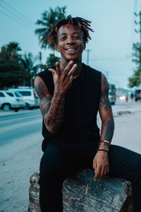 Portrait of smiling young man sitting outdoors 