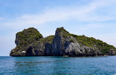 Rock formation in sea against sky