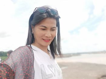 Portrait of smiling young woman standing on beach