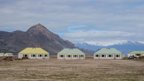 Houses by mountains against sky