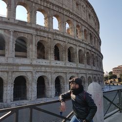 Man looking at coliseum in city