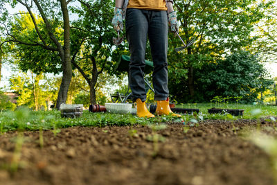 Unrecognisable female gardener standing in her ornamental backyard garden. planting seedlings.