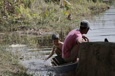 Man with son in boat on lake