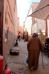 Rear view of people walking on street amidst buildings