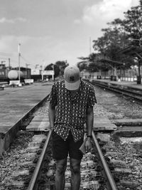 Man standing on railroad track against sky