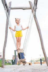 Full length of woman sitting on slide at playground