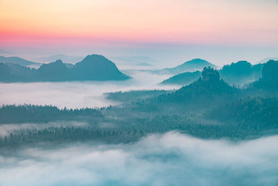 Scenic view of majestic mountains against sky during sunset