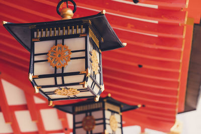 Close-up of electric lamp on table against building