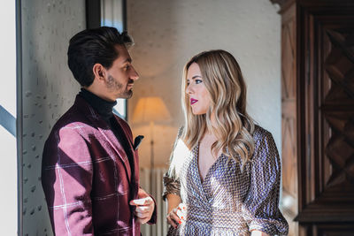 Young couple standing against wall