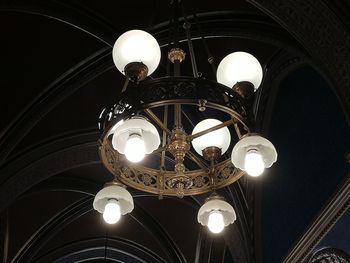 Low angle view of illuminated chandelier hanging in building