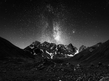 Scenic view of snowcapped mountains against sky at night