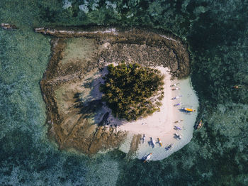 Aerial view of boats moored at beach on island