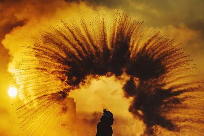 Silhouette man standing against sky at sunset