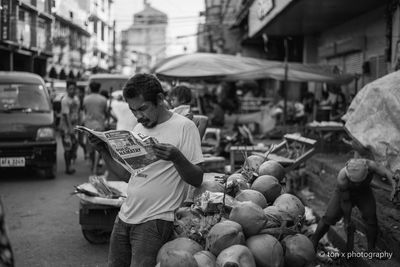 Man holding ice cream at market stall in city