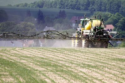 Scenic view of agricultural field and machinery against sky