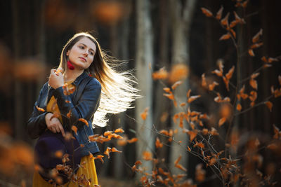 Young woman holding leaves during autumn