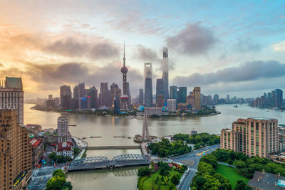 Buildings in city against cloudy sky