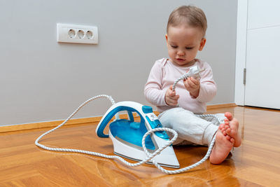 Portrait of cute baby boy sitting on sofa at home