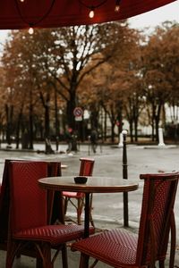 Empty chairs and tables at sidewalk cafe