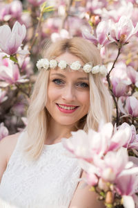 Portrait of beautiful woman standing by flowers