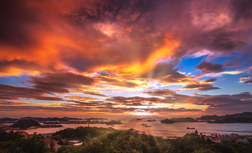 Scenic view of sea against dramatic sky during sunset