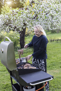 Woman making barbecue at backyard