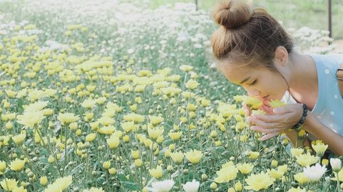 Close-up of woman smelling yellow flowers